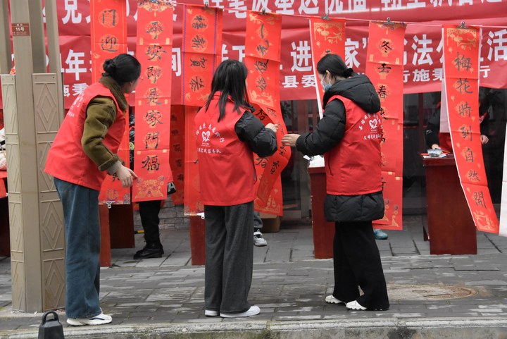 圖為志愿者對春聯進行整理供群眾挑選。