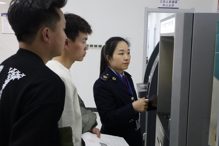 稅務(wù)人員輔導(dǎo)納稅人開具發(fā)票。張旭東攝