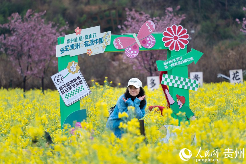 游客在油菜花中打卡拍照。人民網記者 涂敏攝