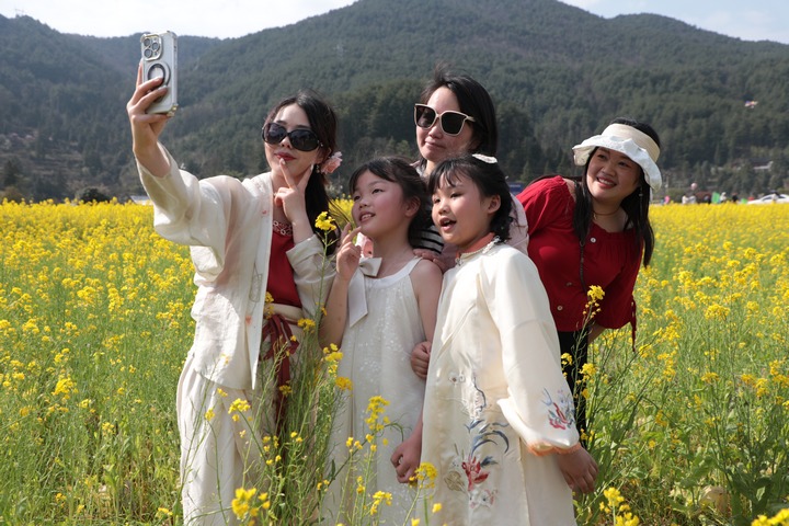 圖為游客們?cè)谟筒嘶ㄌ锢锱恼沾蚩ā? /></p>
<p style=