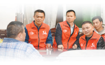 游德祥（右二）和志愿者一起走訪困難司機。吳 杰攝