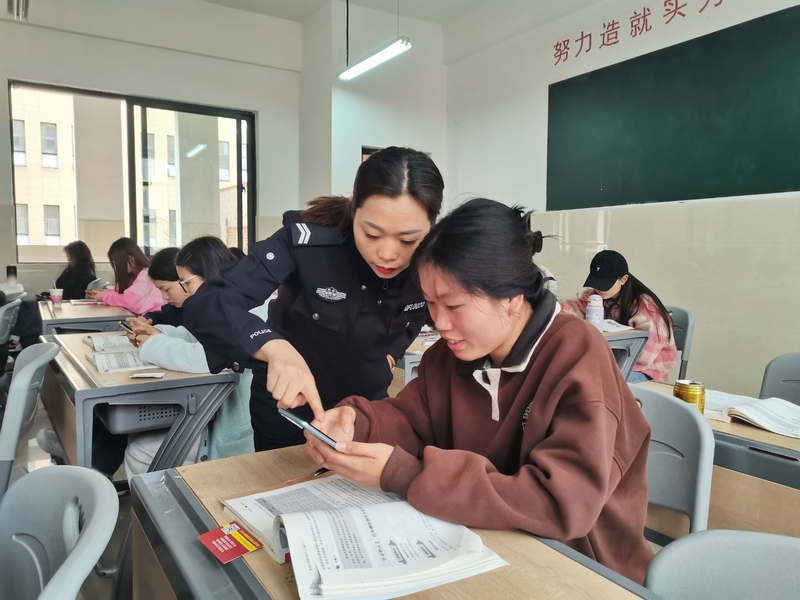 民警指導學生下載“國家反詐中心”APP。