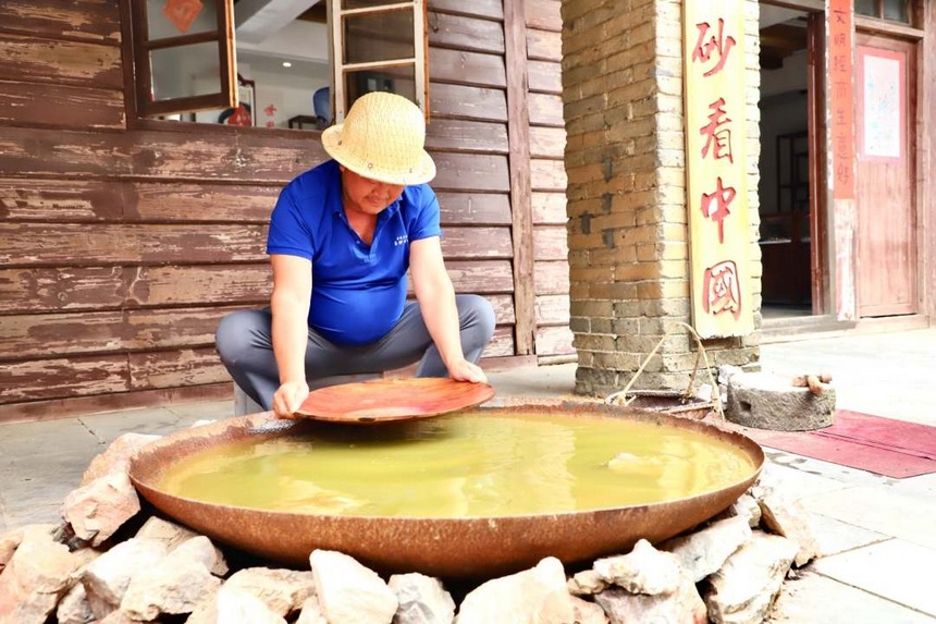 圖為淘洗礦石，提取朱砂。顧蘭云攝