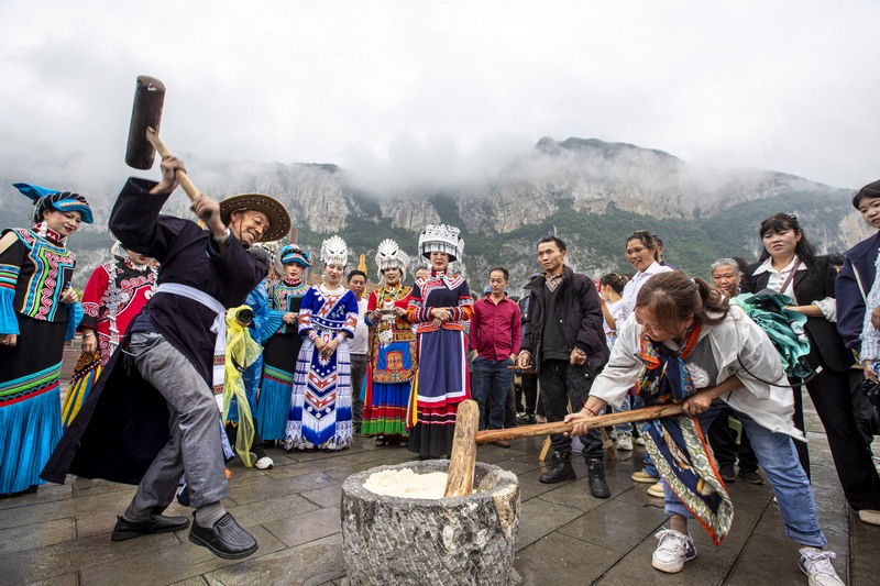 6月7日，貴州省畢節(jié)市黔西市新仁苗族鄉(xiāng)化屋村，村民們和游客打糍粑。