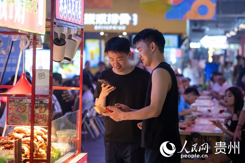 6月21日，在青云市集內，游客正用手機拍攝美食。人民網記者 翁奇羽攝