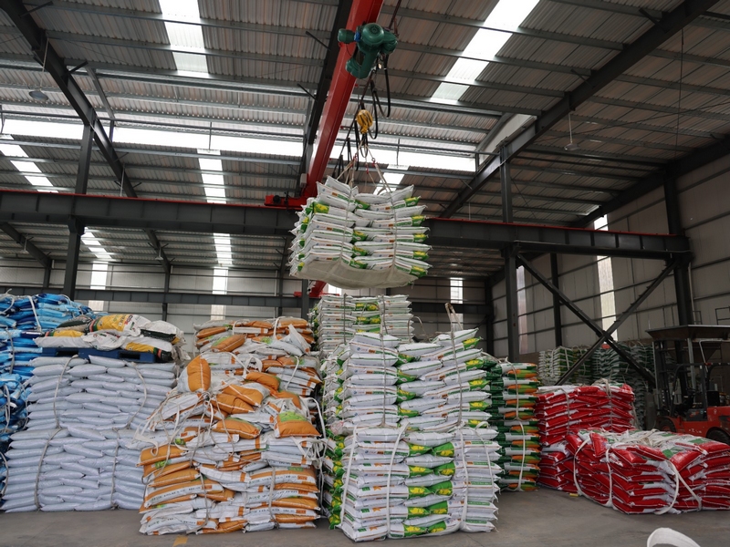 一袋袋包裝好的復(fù)合肥從傳送帶上快速運(yùn)轉(zhuǎn)，被智能機(jī)械手臂抓取碼垛 修文縣融媒體中心李云 攝