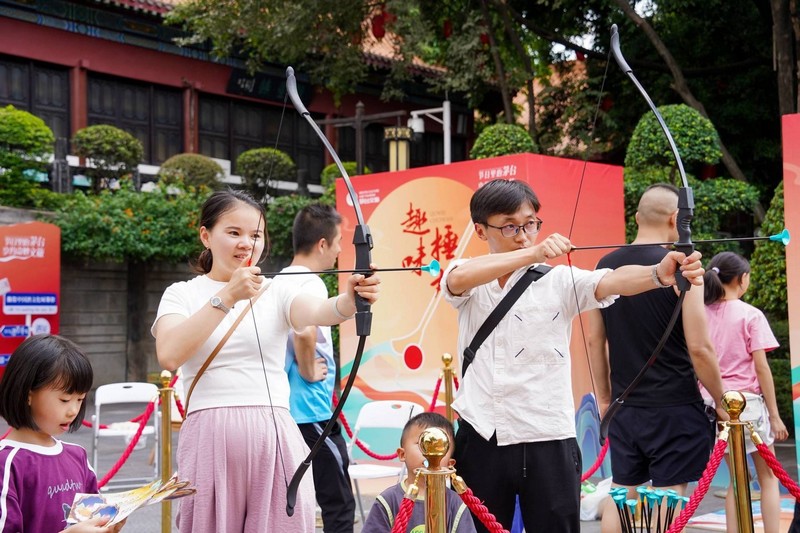 游客們在傳統(tǒng)游戲區(qū)體驗射箭項目.jpg