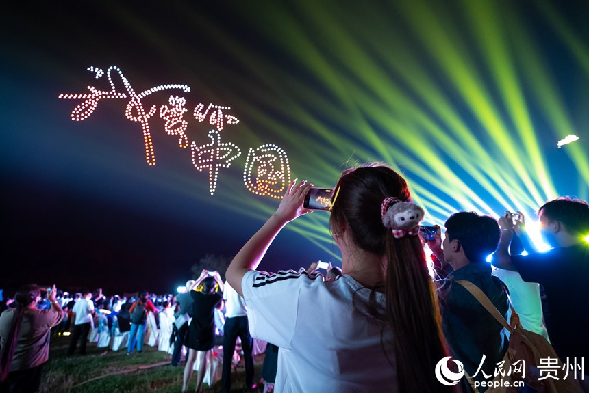 游客在云峰屯堡內(nèi)觀看無(wú)人機(jī)燈光秀。人民網(wǎng)記者 涂敏攝