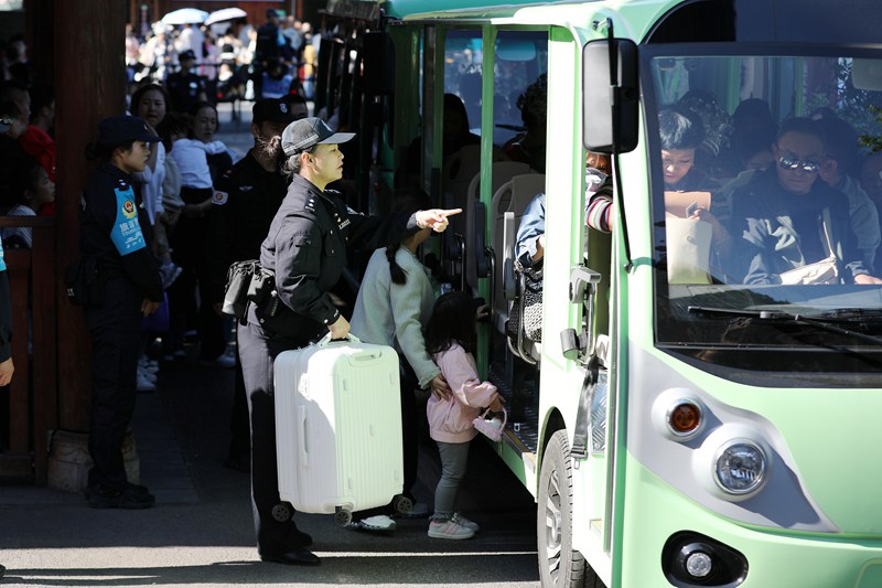 10月4日，雷山縣公安局輔警在西江千戶苗寨一號橋服務群眾乘坐觀光車。