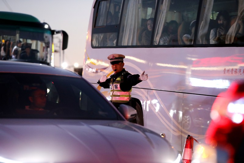 10月4日，雷山縣公安局交警大隊(duì)輔警在西江千戶苗寨景區(qū)營上路口疏導(dǎo)交通。