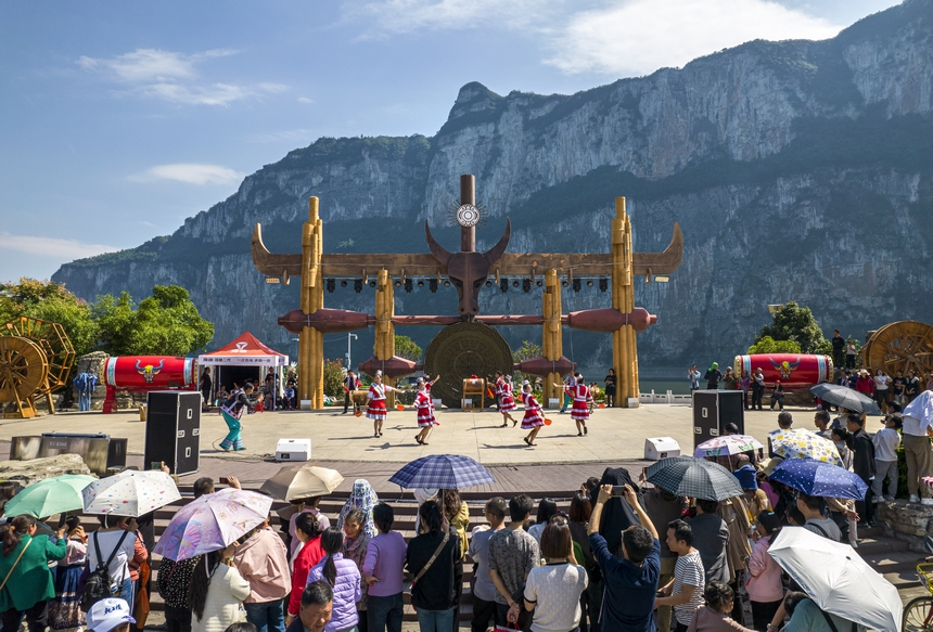 貴州省黔西市烏江源百里畫廊化屋景區，游客觀賞當地苗族村民表演原生態歌舞（無人機照片）。