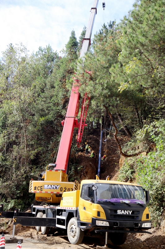 起重機將供水主管道高高吊起,工人們正加緊施工,焊接、埋管等工序有條不紊 修文縣融媒體中心文俊入 攝