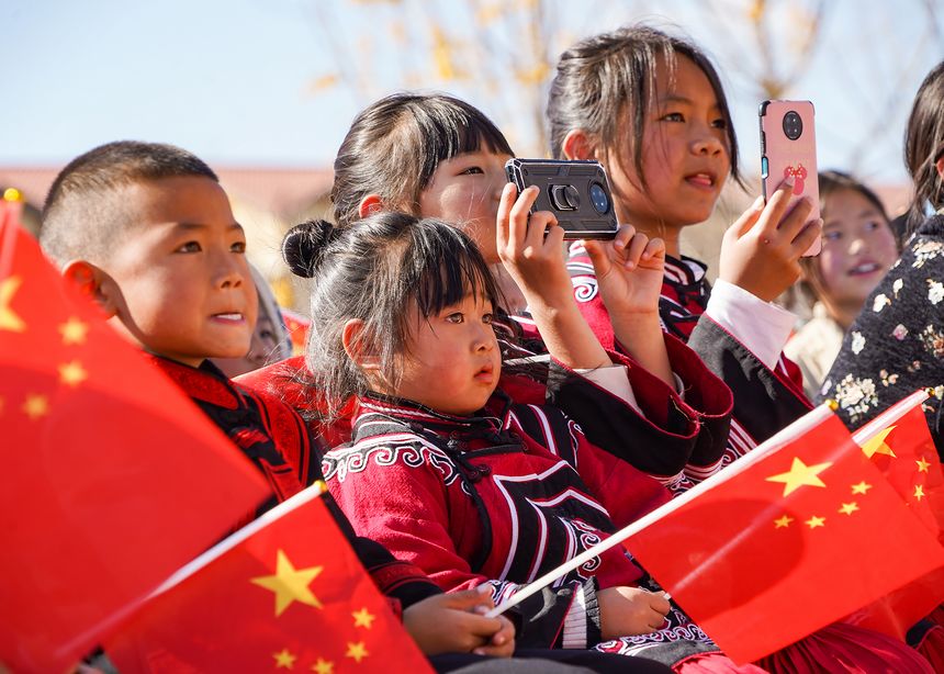 慰問演出現(xiàn)場，身著民族服飾的觀眾用手機記錄精彩瞬間。趙慶能攝