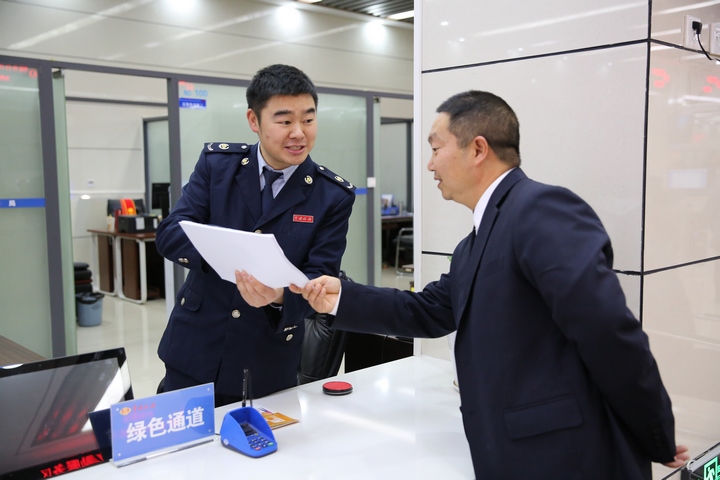 窗口人員為前來辦理契稅申報繳納的納稅人解讀契稅新政。鄭婷攝