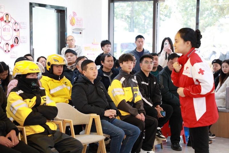 鄒冉(一排左三)、胡紅心(一排左四)等人認真聆聽區紅十字會老師講解應急救護知識