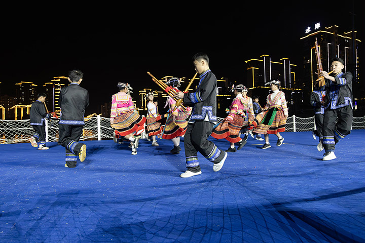 學(xué)生在貴州省黔南布依族苗族自治州羅甸縣玉湖公園水上舞臺表演蘆笙舞。 