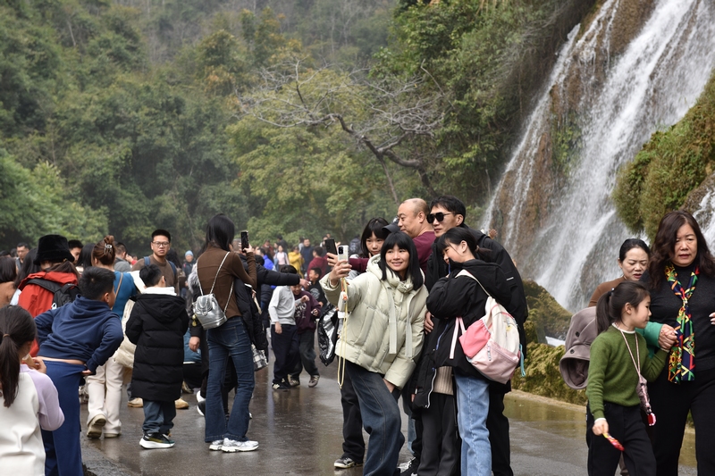 拉雅瀑布前游客打卡拍照留念。