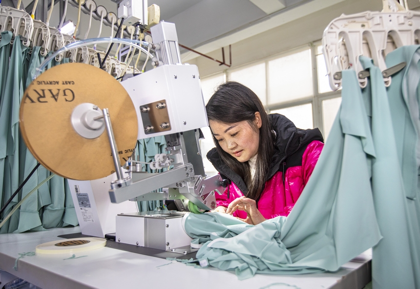 2025年2月5日，工人在貴州省畢節市黔西市經濟開發區一家服飾企業車間生產線上作業。