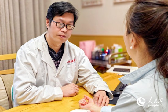 中醫(yī)館里,一名中醫(yī)正在把脈問(wèn)診。人民網(wǎng) 程明輝攝