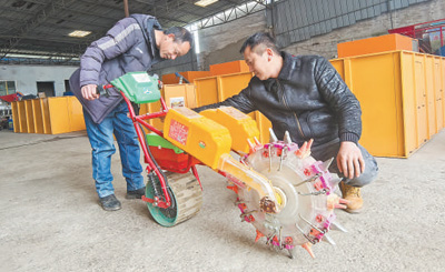 杜蘇林(右)在介紹新款電動式自動播種機。