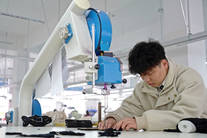 2025年2月25日,位于貴州省畢節市納雍縣工業園區的貴州博澤服裝有限公司生產車間,工人在趕訂單。 楊英 攝.jpg