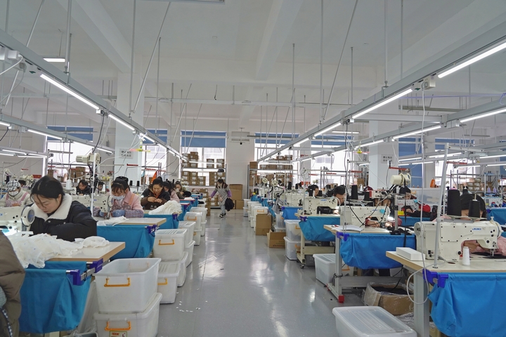 2025年2月25日,位于貴州省畢節市納雍縣工業園區的貴州博澤服裝有限公司生產車間,工人在趕訂單。 楊 英 攝.jpg