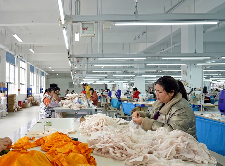 2025年2月25日,位于貴州省畢節市納雍縣工業園區的貴州博澤服裝有限公司生產車間,工人在趕訂單。 楊英 攝.jpg