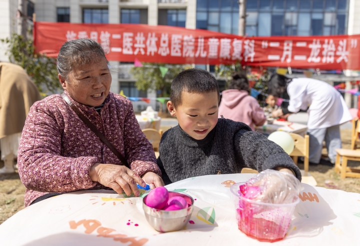 2025年2月28日,貴州省黔東南苗族侗族自治州施秉縣第二醫(yī)共體總醫(yī)院兒童康復科,家長在指導孩子染紅蛋。(磨桂賓 攝) (1).jpg