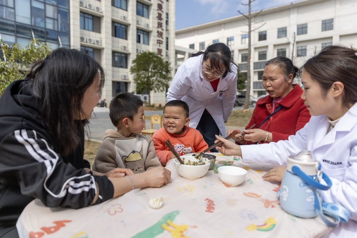 2025年2月28日,貴州省黔東南苗族侗族自治州施秉縣第二醫(yī)共體總醫(yī)院兒童康復科護士與家長一起指導孩子包餃子。(磨桂賓 攝) (3).jpg