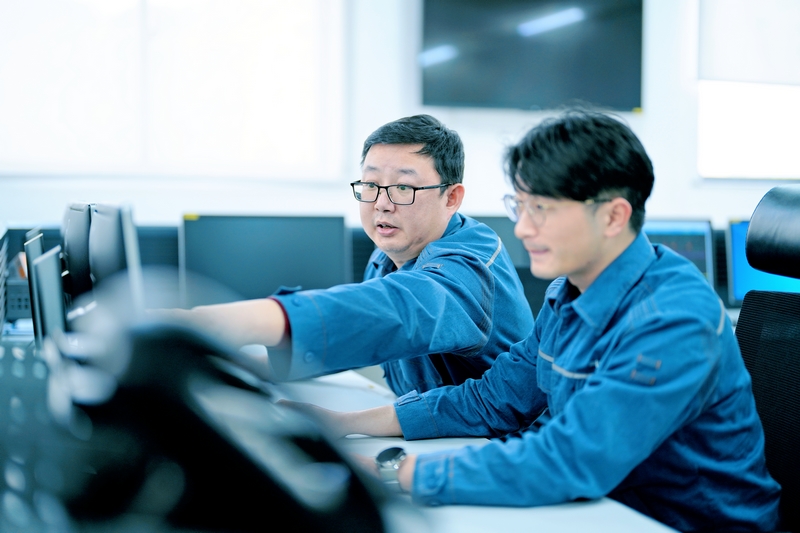 周敬余（左）給新員工講解監(jiān)控信號的作用。陳濤攝
