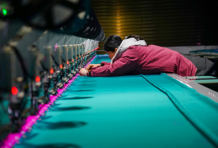 在貴州省從江縣美娥社區(qū)一家民族刺繡企業(yè)生產(chǎn)車間，工人在用數(shù)控機(jī)床生產(chǎn)刺繡產(chǎn)品。