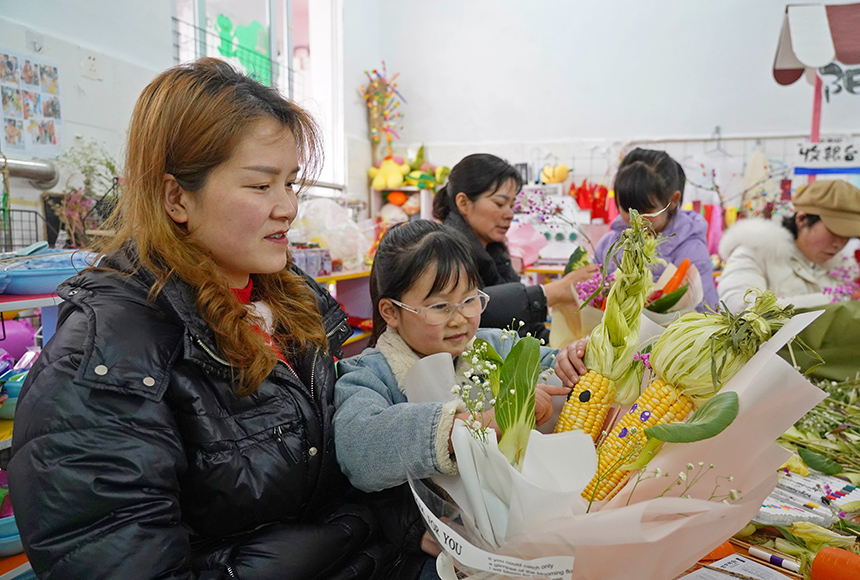 2025年3月6日，貴州省畢節市納雍縣龍場鎮中心幼兒園“溫情三八·感恩有您”活動現場，家長和孩子們一起做手工。  楊  英 攝