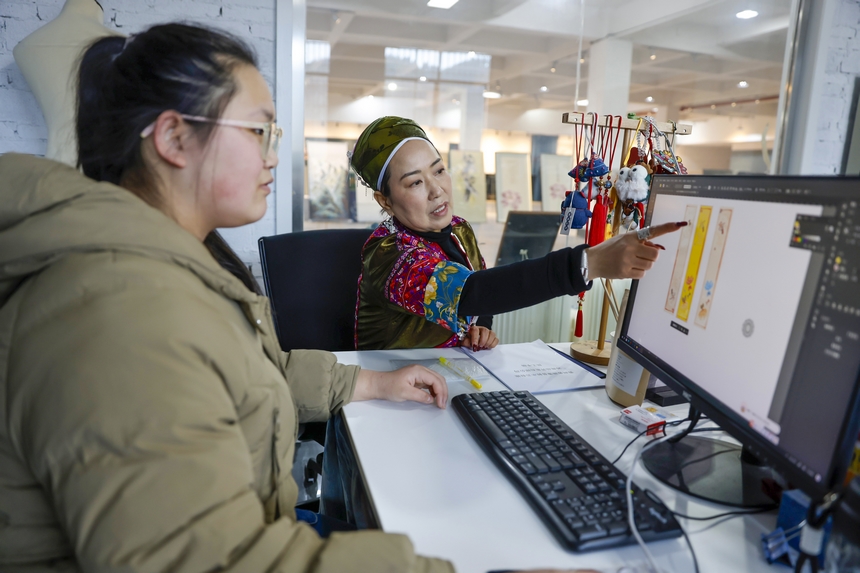 龍祿穎（右）與公司設計師討論新產品設計方案。