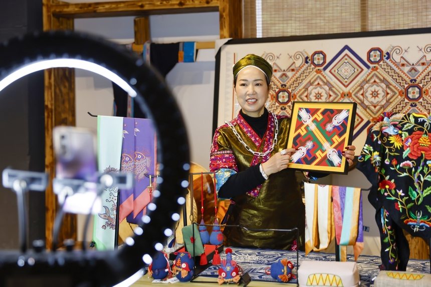 龍祿穎在公司的鄉村振興直播間推介苗繡文創產品。