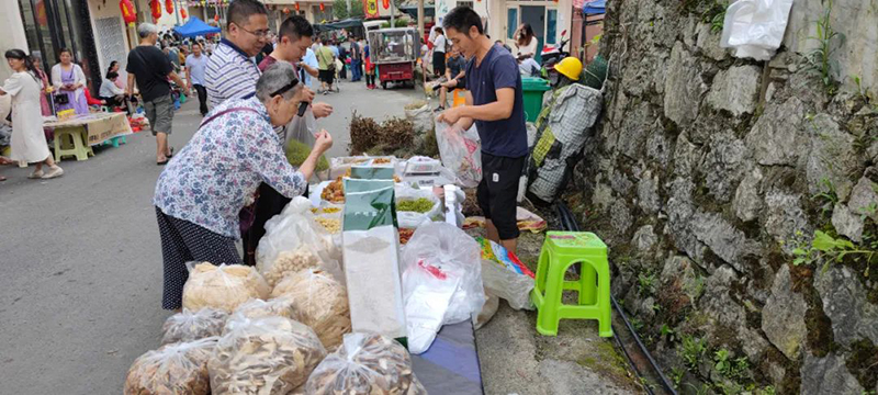 游客在鄉村集市購買土特產。桐梓縣融媒體中心供圖