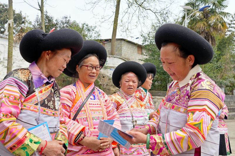 2025年4月8日,貴州省畢節市納雍縣新房彝族苗族鄉得勒科村文化廣場,“法律明白人”用苗語講解普法宣傳折頁內容。 楊英 攝
