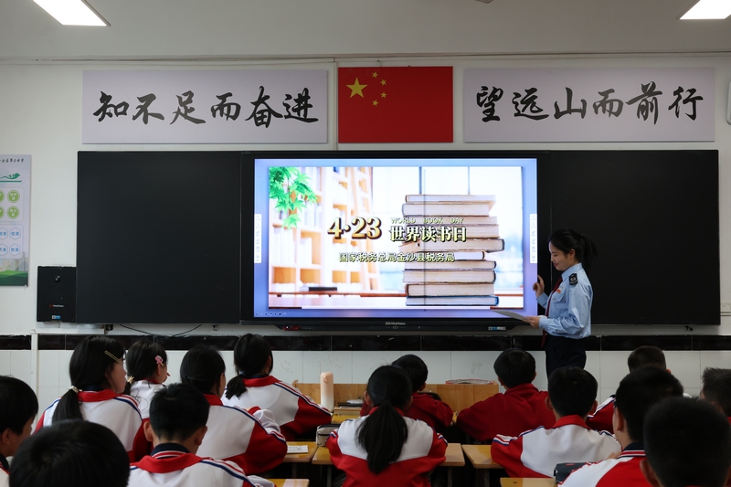 國家稅務總局金沙縣稅務局青年干部利用世界讀書日，與金沙縣第三中學聯合開展主題課堂。圖為稅務干部為青少年講解閱讀方法。朱泫粼