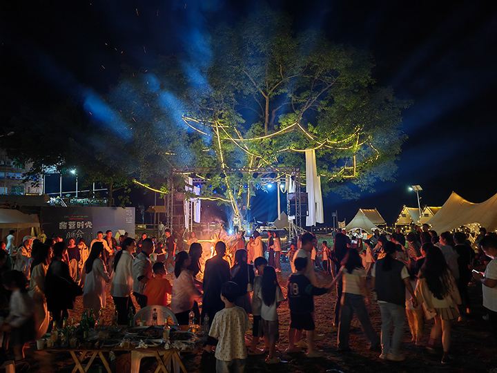 4、游客夜晚圍坐篝火旁，品嘗燒烤、仰望星空，沉浸于“時光音樂會”的民謠彈唱中。王琨榮攝