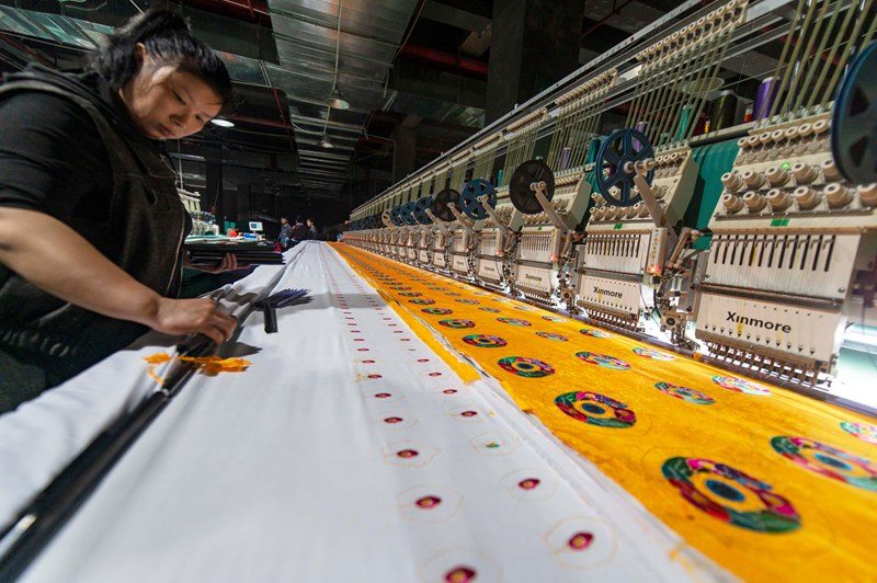 2025年5月7日，在貴州省從江縣一家民族刺繡企業生產車間，工人在用數控機床生產刺繡產品 。