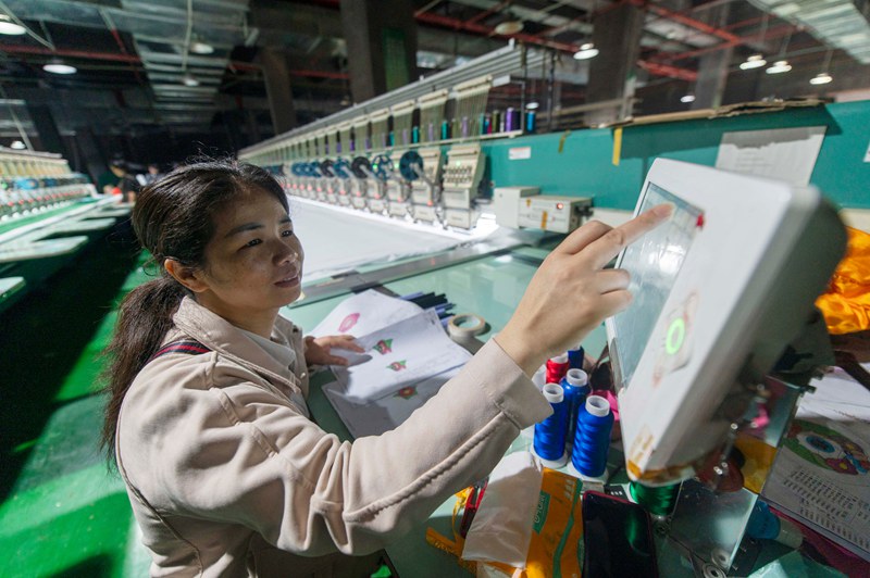 2025年5月7日，在貴州省從江縣一家民族刺繡企業生產車間，工人在用數控機床生產刺繡產品 。