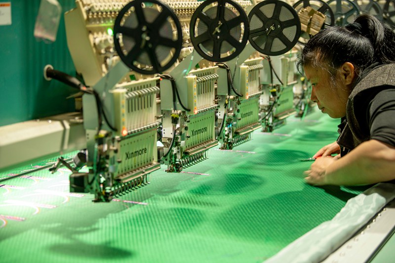 2025年5月7日，在貴州省從江縣一家民族刺繡企業生產車間，工人在用數控機床生產刺繡產品 。