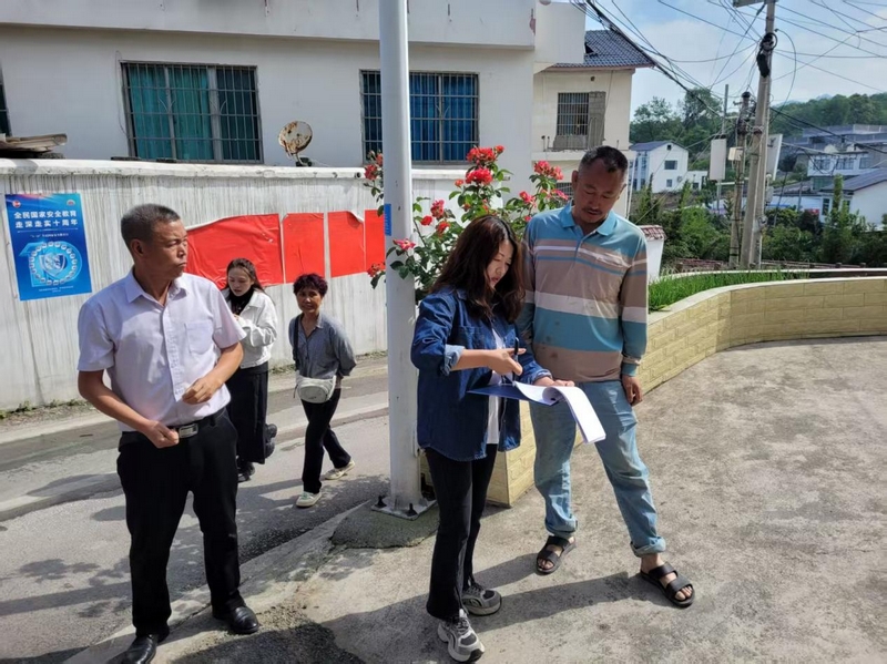 貓洞村的村支兩委干部走訪群眾。