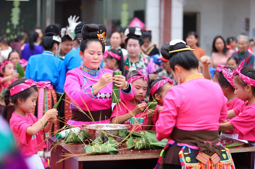 2025年5月29日，在貴州省丹寨縣金泉街道，身著傳統服飾的搬遷群眾在參加包粽子比賽。