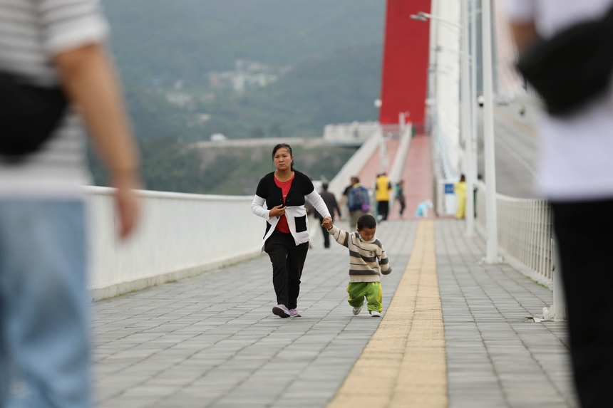 游客行走在龍里河大橋上。