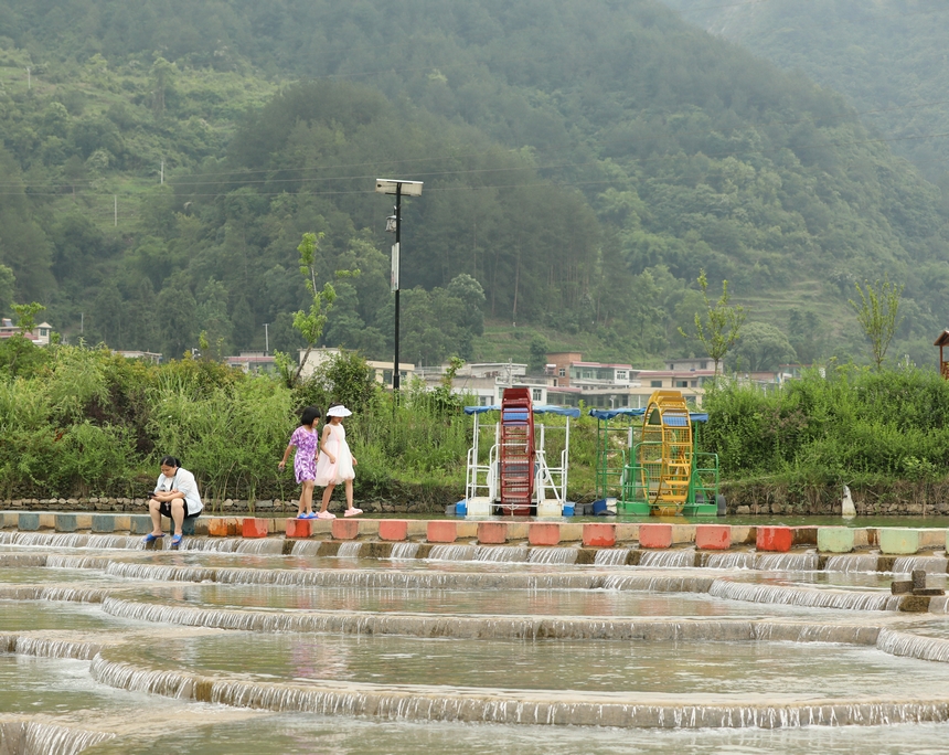 小朋友行走在魚鱗壩。