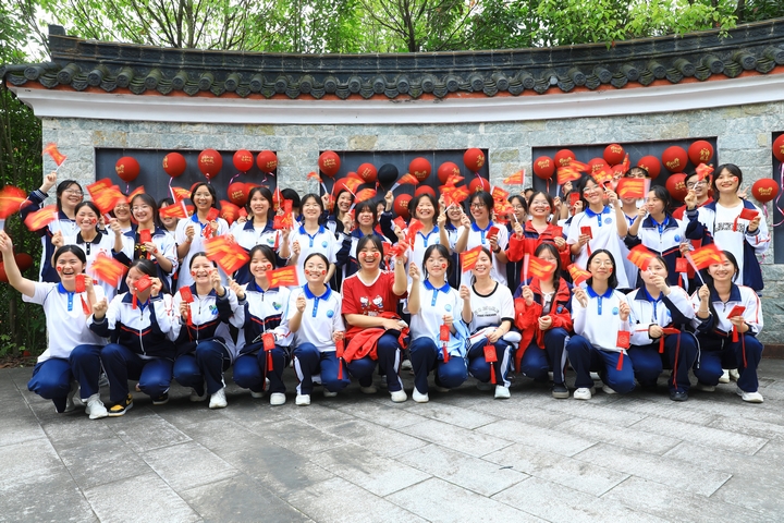 劍河民族中學高三學子手舉“金榜題名錦囊”在狀元亭旁合影。楊潔茹 攝