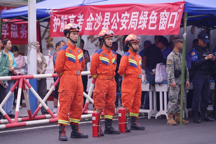 高考期間，消防員身著橙色戰衣、配備裝備，在考點外嚴陣以待，為考生消防安全護航 。王方 攝.jpg