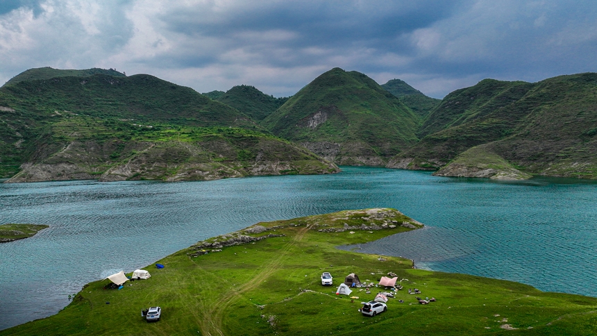 2025年6月14日，游客在在黔西市五里鄉桐山村境內的支嘎阿魯湖畔休閑觀光。