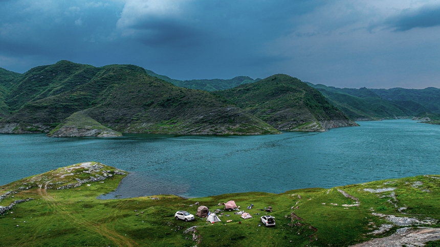 2025年6月14日，游客在在黔西市五里鄉(xiāng)桐山村境內(nèi)的支嘎阿魯湖畔休閑觀光。