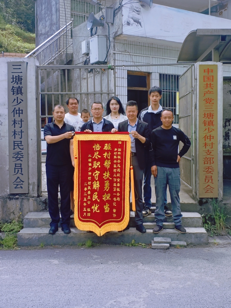 村委會為稅務(wù)干部送上錦旗并合影。村委會供圖